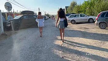 Two young women go topless and expose their private parts in a public place