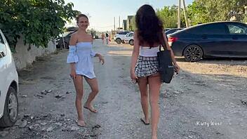Two young women go topless and expose their private parts in a public place