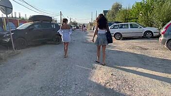 Two young women go topless and expose their private parts in a public place