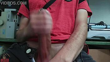 A young skinny gay guy with a small waist masturbates furiously at his desk in the office, stroking his huge monster cock while fearing his boss might walk in and catch him in the act