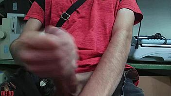 A young skinny gay guy with a small waist masturbates furiously at his desk in the office, stroking his huge monster cock while fearing his boss might walk in and catch him in the act