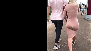Beautiful blonde in dress poses outdoors and shows her ass