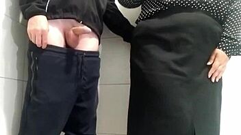 gorgeous milf gives sneaky handjob in public toilet stall
