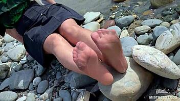 goddess in tan nylons shows cute nylon soles and toes on riverside