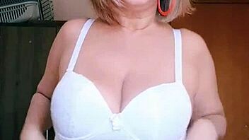 Mature woman models lingerie with big natural tits.