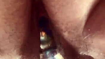 Close-up view of hairy pussy getting worked by a glass dildo in solo play.  