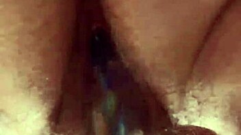 Close-up view of hairy pussy getting worked by a glass dildo in solo play.  
