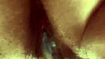 Close-up view of hairy pussy getting worked by a glass dildo in solo play.  