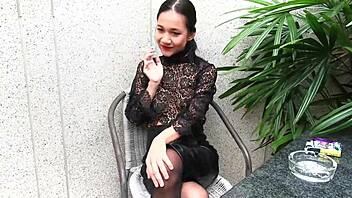 young girl smokes topless in a leather skirt outdoors