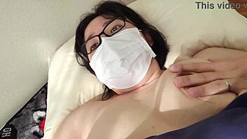 Married Japanese woman masturbates with legs open in explicit video