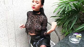 young girl smokes topless in a leather skirt outdoors