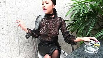 young girl smokes topless in a leather skirt outdoors