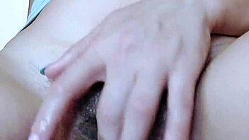A solo girl plays with her pussy, shaking legs from orgasm