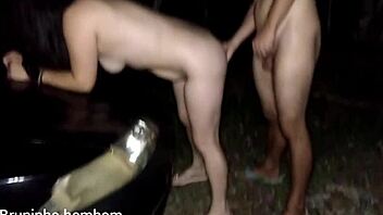 Brazilian woman banged on car hood outdoors.