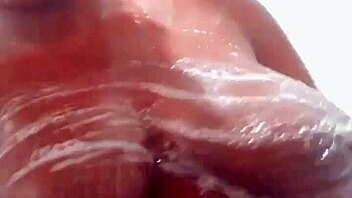 Ebony woman washes her natural tits with soap