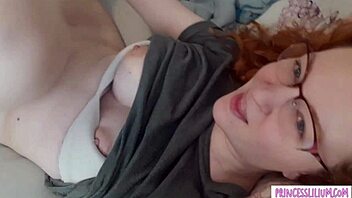A girl with glasses plays with a modestly big breast