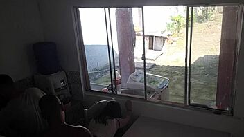 Man with hearing issue washes dishes while wife chats with friend in kitchen