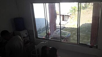 Man with hearing issue washes dishes while wife chats with friend in kitchen