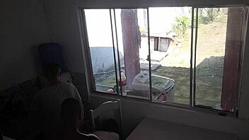 Man with hearing issue washes dishes while wife chats with friend in kitchen