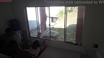 Man with hearing issue washes dishes while wife chats with friend in kitchen