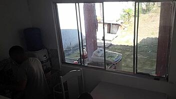 Man with hearing issue washes dishes while wife chats with friend in kitchen