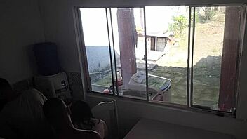 Man with hearing issue washes dishes while wife chats with friend in kitchen