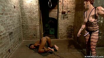 Latex lezdom casually whips her ebony slave.