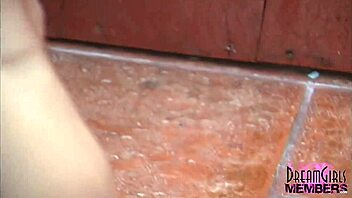 Is this tanned brunette shaving in outdoor shower?