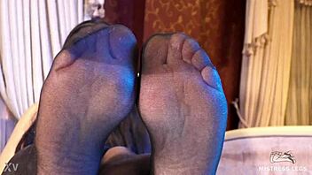 sexy goddess in black pantyhose with rose print on heels teases you with her feet