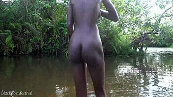 Skinny adorable African girl bathes in the village river