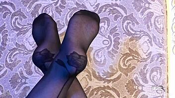 sexy goddess in black pantyhose with rose print on heels teases you with her feet