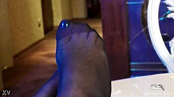 sexy goddess in black pantyhose with rose print on heels teases you with her feet