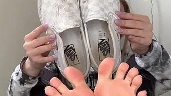 A Serbian girl removes her sneakers to reveal her bare feet.