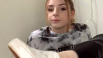 A Serbian girl removes her sneakers to reveal her bare feet.