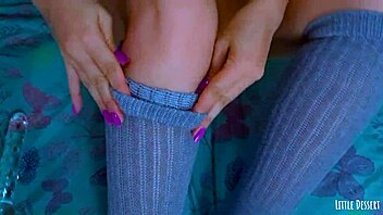 Young girl with painted toenails uses glass dildo on her soles and toes
