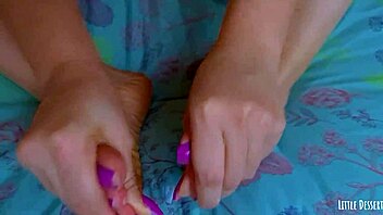 Young girl with painted toenails uses glass dildo on her soles and toes