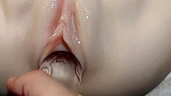 fake cock slides into her shaved pussy for double penetration fun