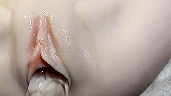 fake cock slides into her shaved pussy for double penetration fun