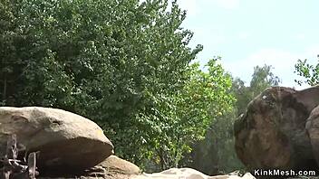 Natural huge tits slave endures rough anal fucking with bondage and bizarre fetish elements outdoors.