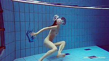 Martina glider i blå bikini för undervattenssim, visar tight europeisk kropp i poolen