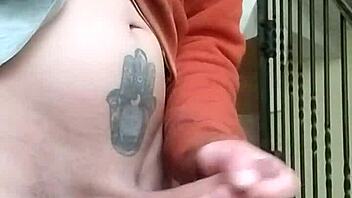 Amateur guy masturbates with huge cock in apartment garage while neighbor chats on phone nearby.