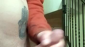 Amateur guy masturbates with huge cock in apartment garage while neighbor chats on phone nearby.