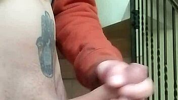 Amateur guy masturbates with huge cock in apartment garage while neighbor chats on phone nearby.