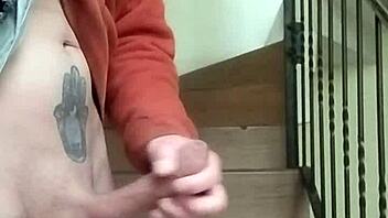 Amateur guy masturbates with huge cock in apartment garage while neighbor chats on phone nearby.