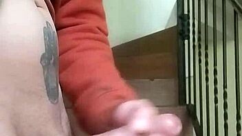 Amateur guy masturbates with huge cock in apartment garage while neighbor chats on phone nearby.