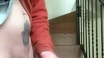 Amateur guy masturbates with huge cock in apartment garage while neighbor chats on phone nearby.