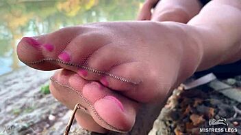 Hey, my cute feet in nude tights rub together teasingly on the autumn river bank outdoors