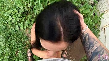 Horny brunette student delivers sloppy blowjob and swallows cum behind the garages in public
