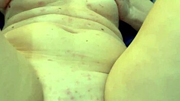 Blonde milf with big tits fingers her wet pussy in POV masturbation.