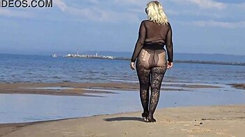 In a black style outfit she flashes confidently on the sunny beach enjoying the outdoor vibe. Nature surrounds her as she poses freely in heels and pantyhose.